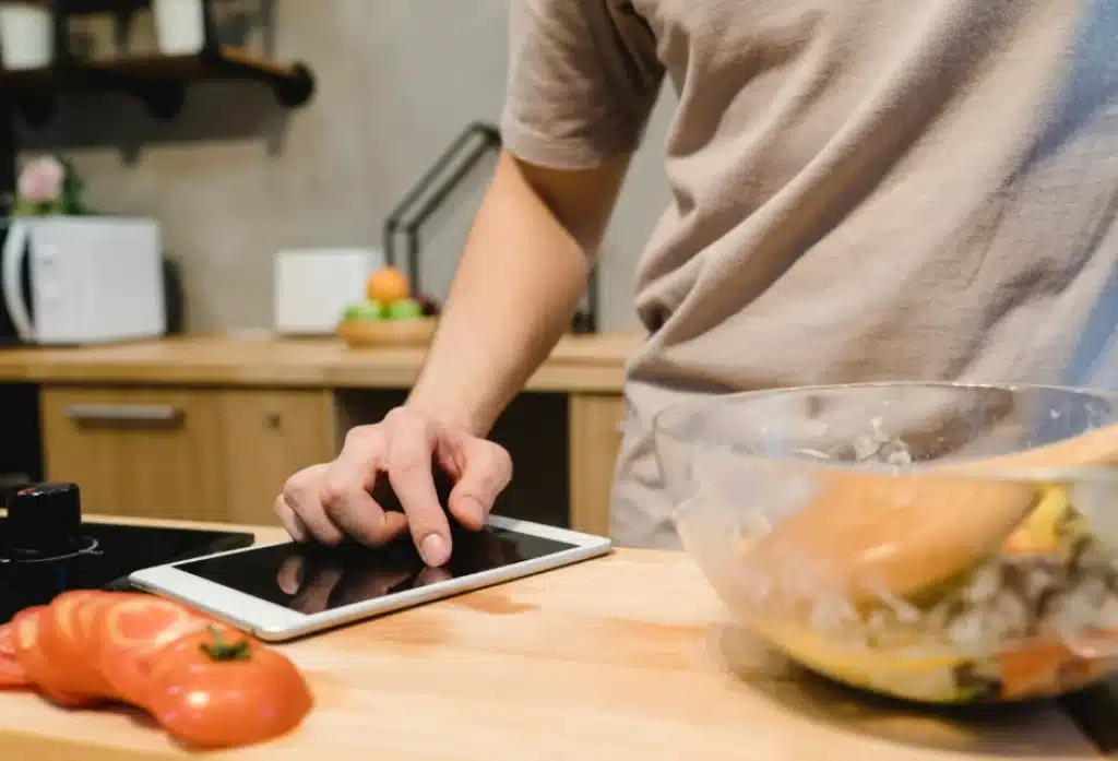 hombre utilizando sus gadgets para cocinar