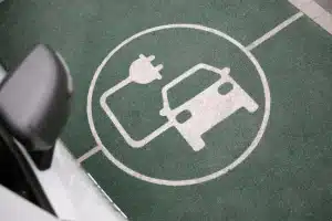 Señalización de estacionamiento para carga de vehículo eléctrico en zona urbana.