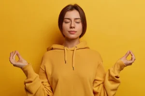 Mujer joven meditando con los ojos cerrados. Representa el equilibrio entre psicología y tecnología.