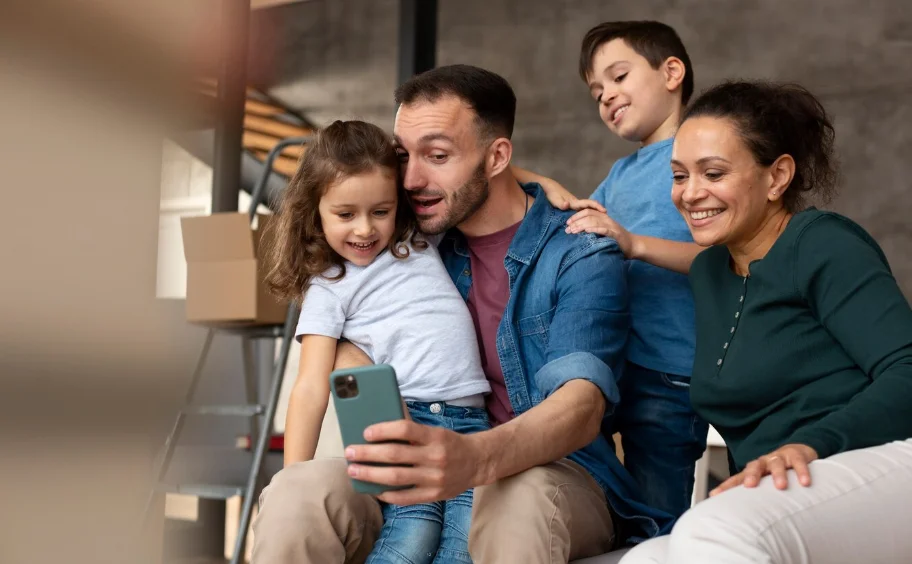 Familia compartiendo el tiempo juntos a través del uso de un teléfono móvil. 