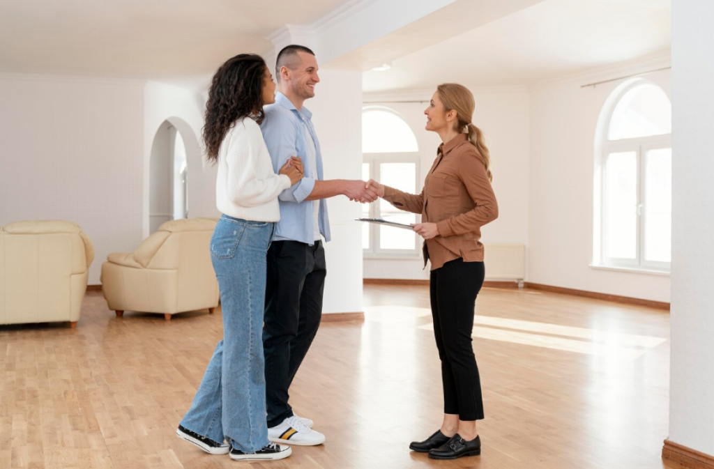 Agente de Inmobiliaria Real Estate cerrando un trato con una pareja de clientes gracias al marketing inmobiliario digital