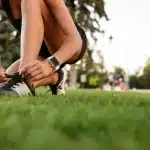 Mujer atándose las botas deportivas antes de realizar actividad física