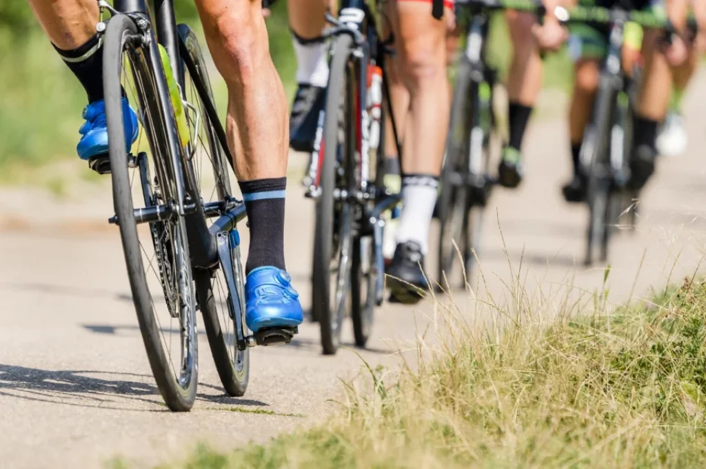 Un grupo de ciclistas pedaleando en un recorrido al aire libre, mostrando sus bicicletas de alto rendimiento y equipo deportivo especializado.