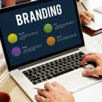 Persona trabajando en una laptop con un gráfico que explica los elementos clave del branding en redes sociales, incluyendo investigación, análisis e ideas.