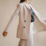 ujer modelando un traje blanco elegante con blazer y pantalones de corte moderno