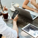 Reunión de trabajo al aire libre con ordenador, tablet y móvil, planificando estrategia digital