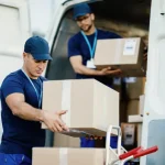 Servicios de paquetería internacional con repartidores cargando paquetes en una furgoneta