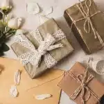 Regalos originales para una boda con envoltorios elegantes, flores blancas y detalles decorativos sobre fondo neutro